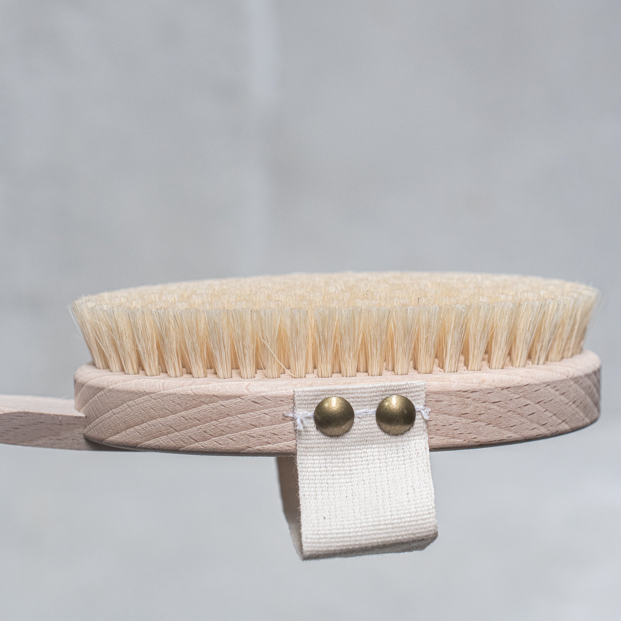 Natural bristle bath brush with a wooden handle, perfect for exfoliating and invigorating the skin during bath time