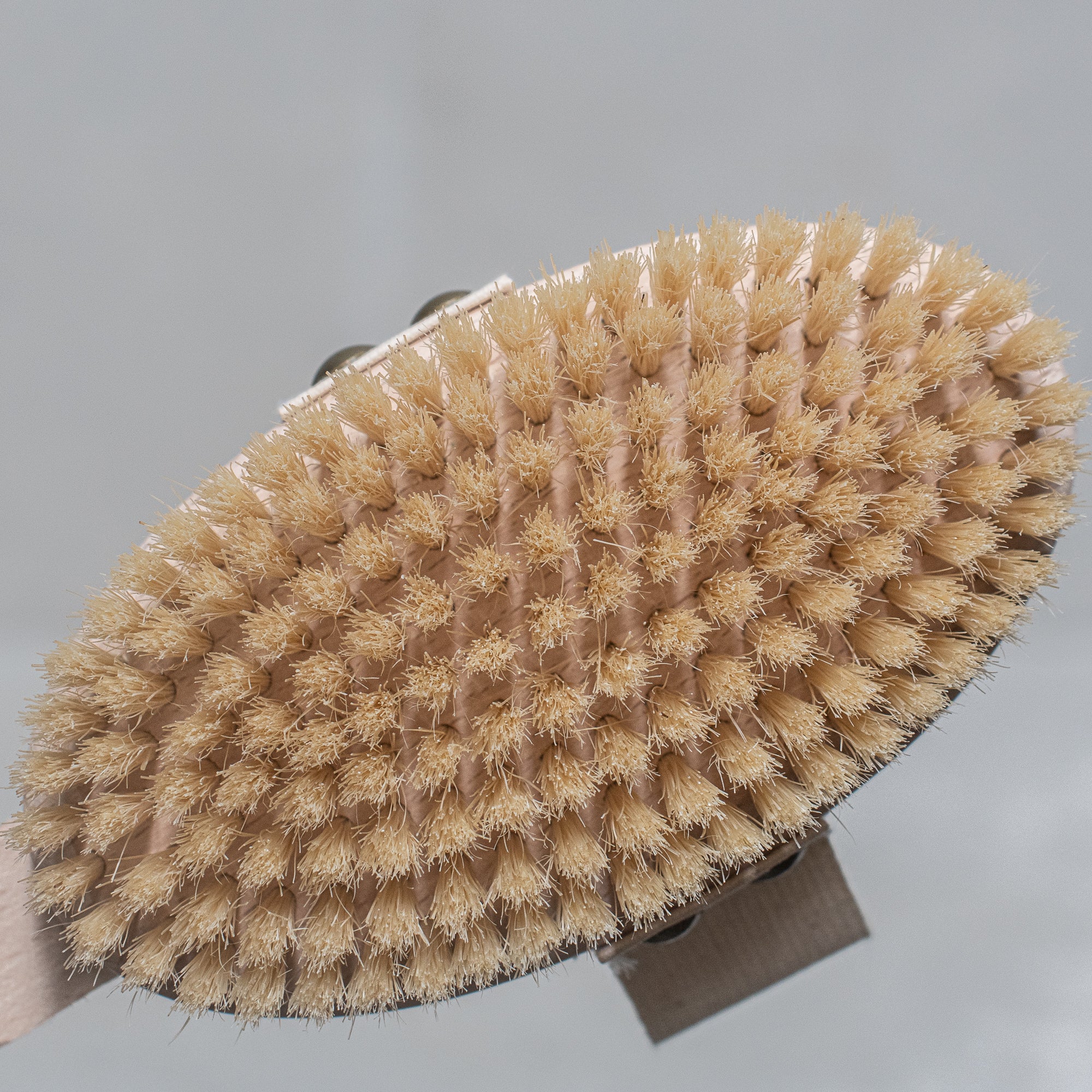 Natural bristle bath brush with a wooden handle, perfect for exfoliating and invigorating the skin during bath time