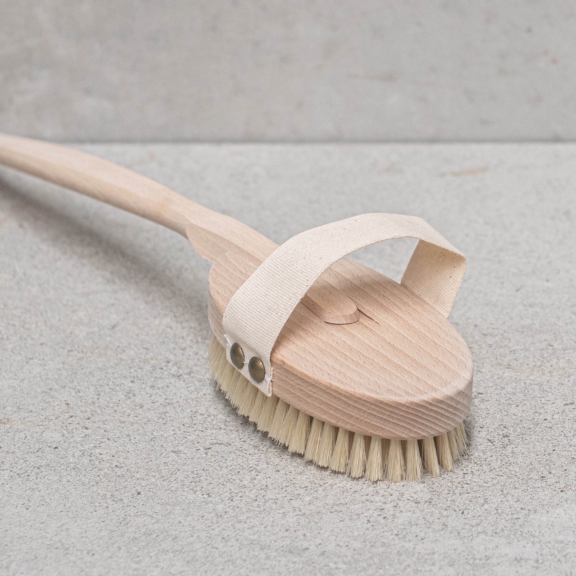 Natural bristle bath brush with a wooden handle, perfect for exfoliating and invigorating the skin during bath time