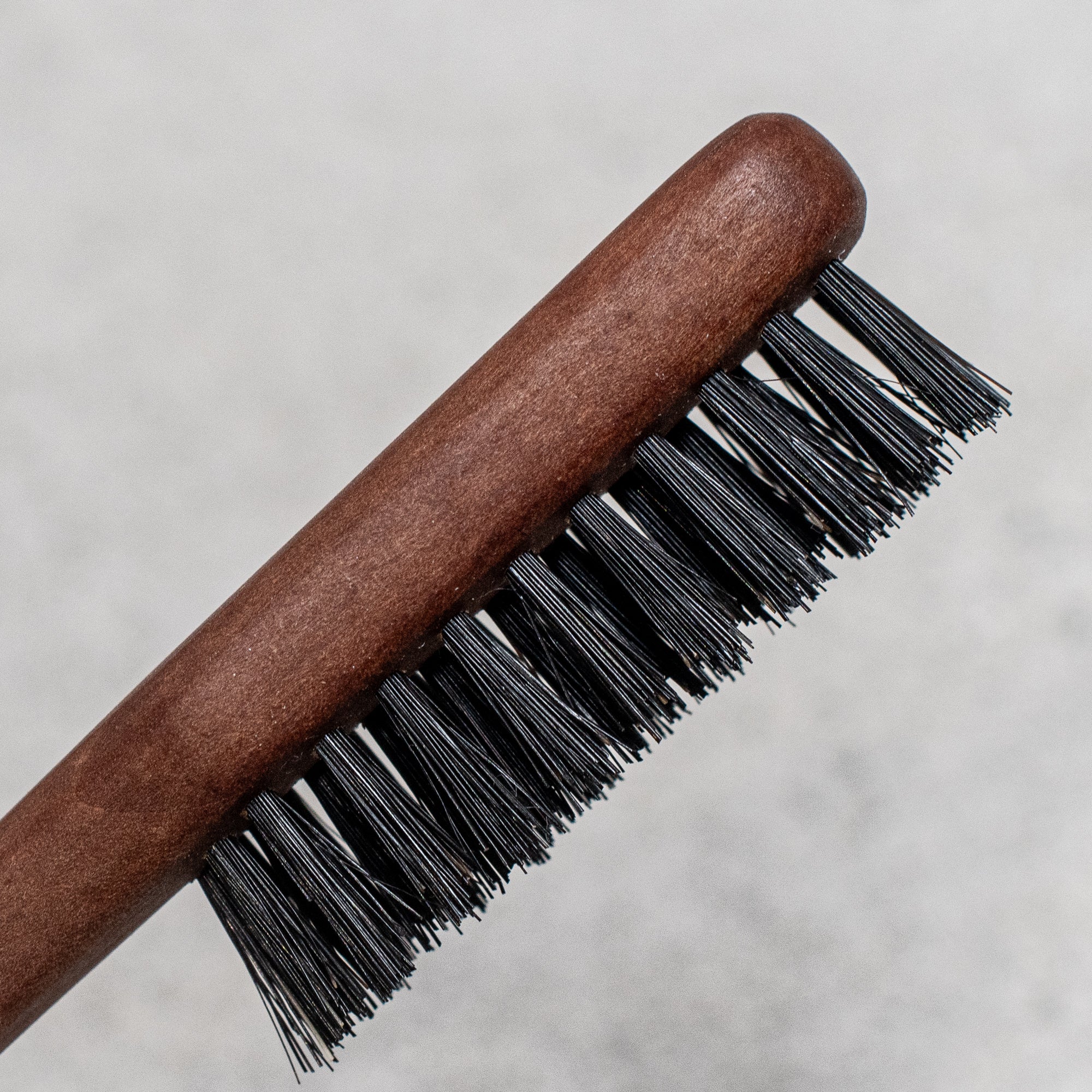 Fibre and timber beard brush with natural bristles and a wooden handle, designed to groom and tame facial hair while promoting a smooth, polished look