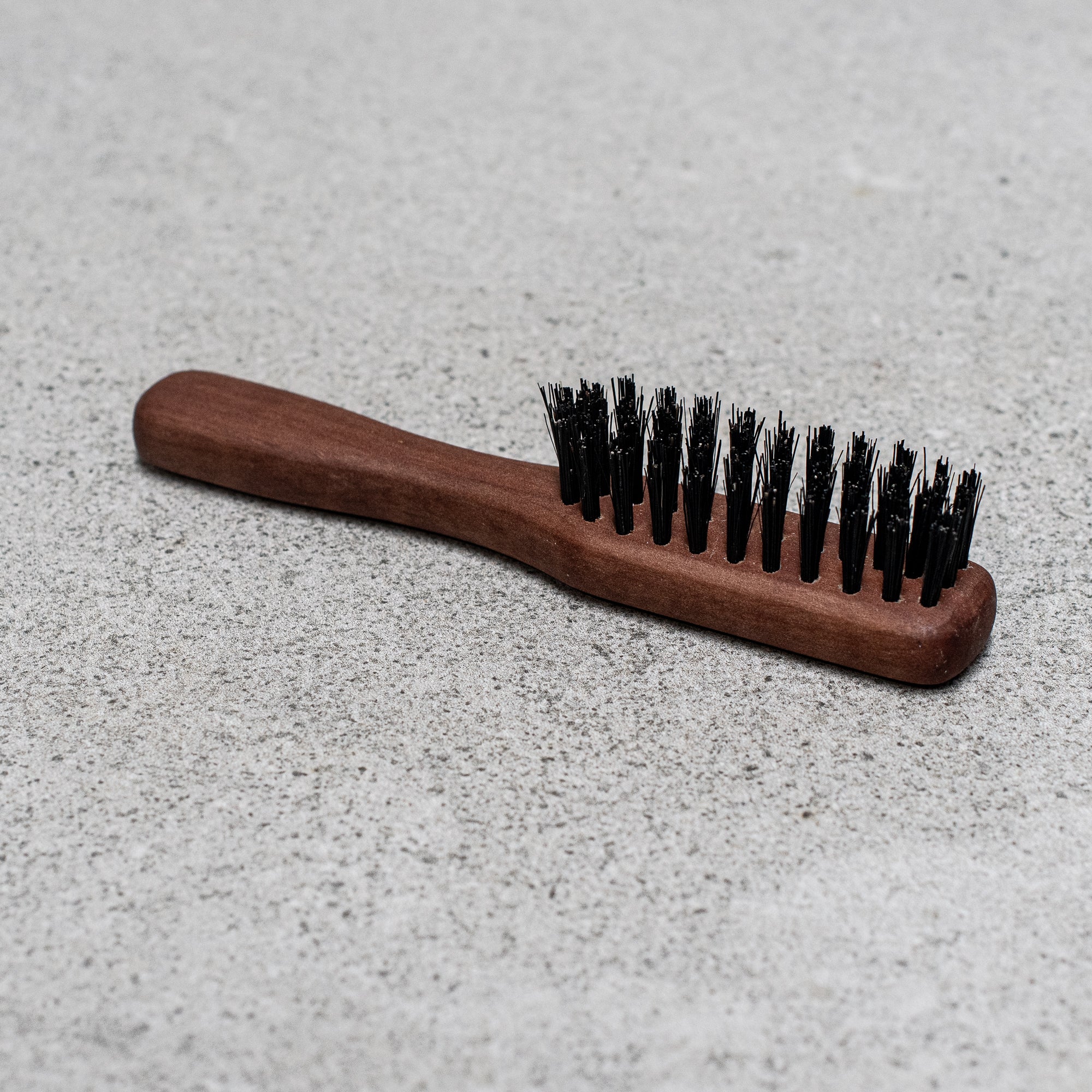 Fibre and timber beard brush with natural bristles and a wooden handle, designed to groom and tame facial hair while promoting a smooth, polished look