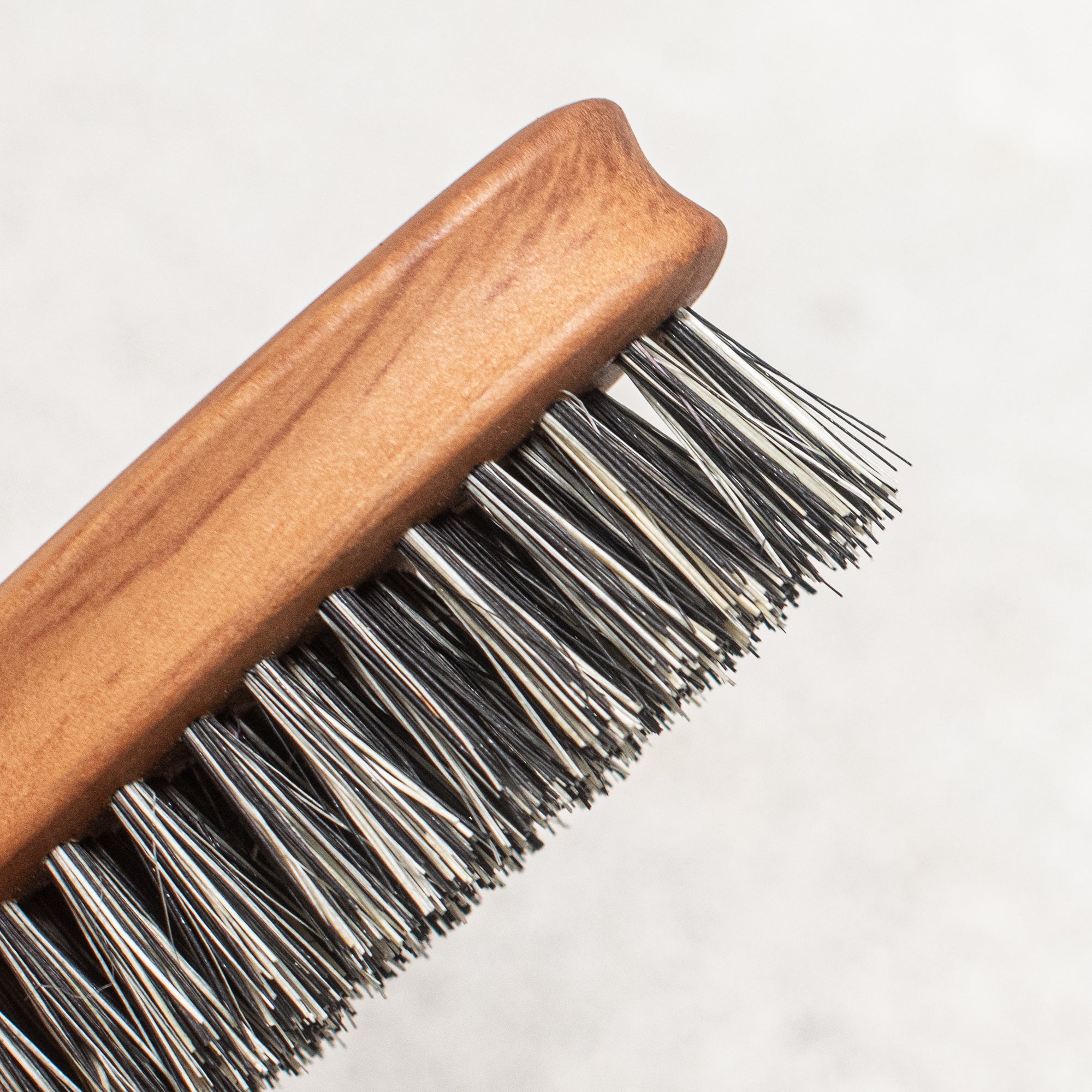 Fibre and timber beard brush with natural bristles and a wooden handle, designed to groom and tame facial hair while promoting a smooth, polished look