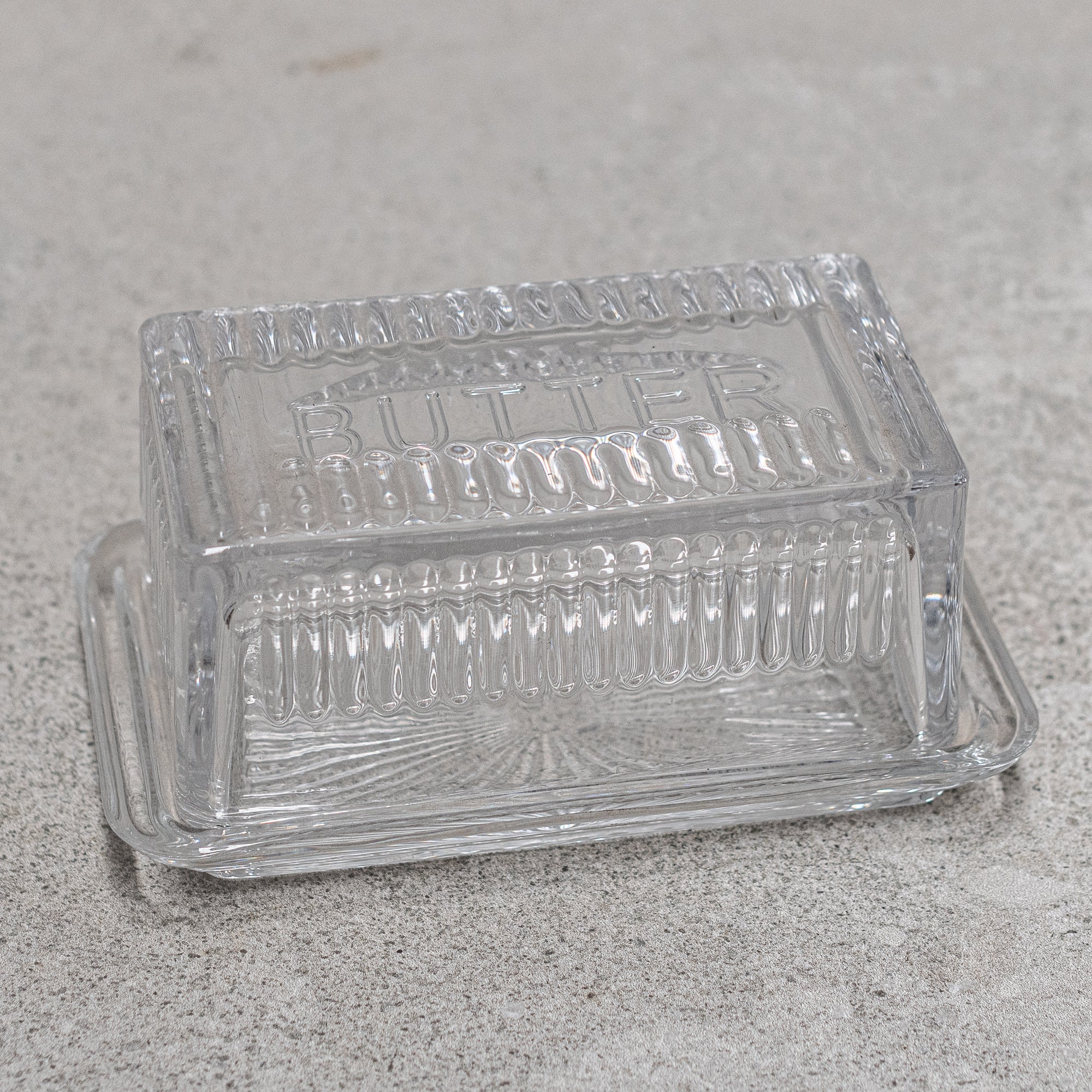 Vintage design glass butter dish, featuring elegant detailing and a classic lid, perfect for keeping butter fresh while adding a nostalgic touch to your table setting