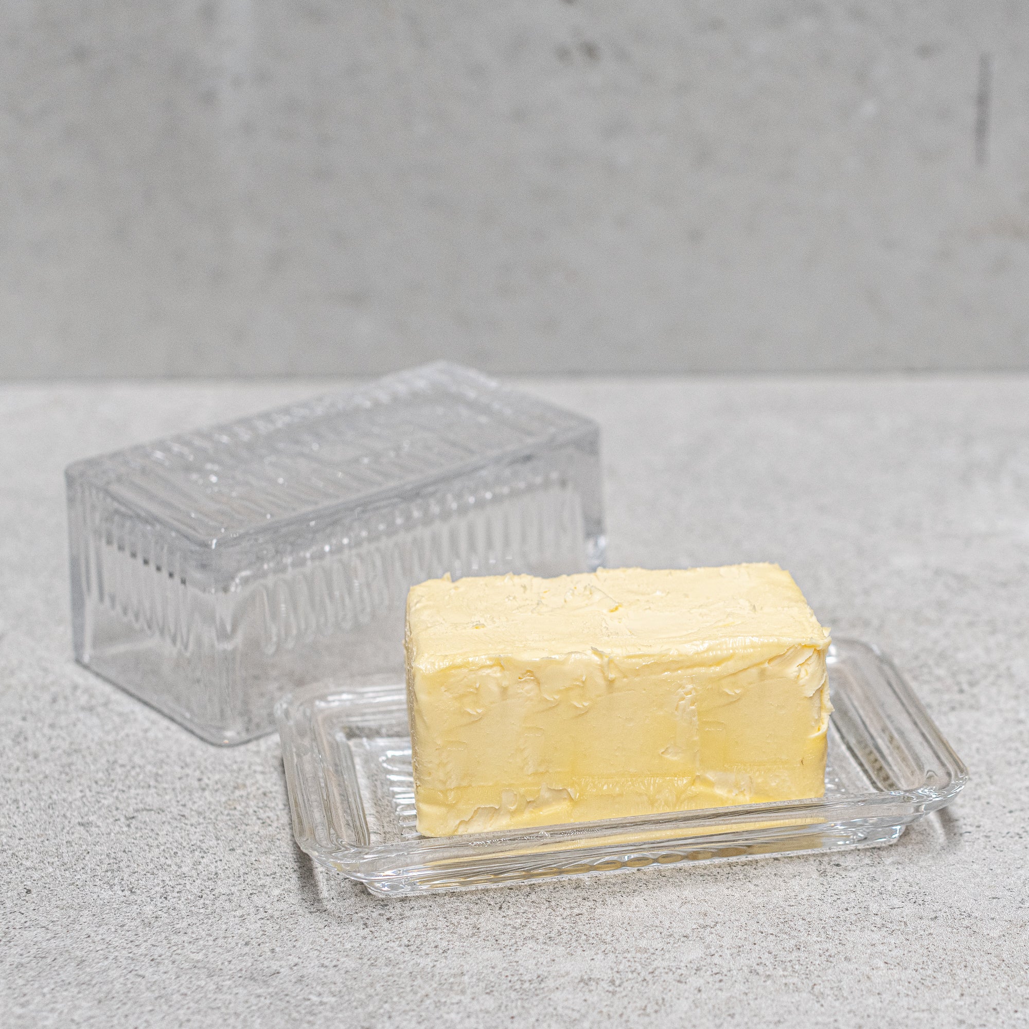Vintage design glass butter dish, featuring elegant detailing and a classic lid, perfect for keeping butter fresh while adding a nostalgic touch to your table setting