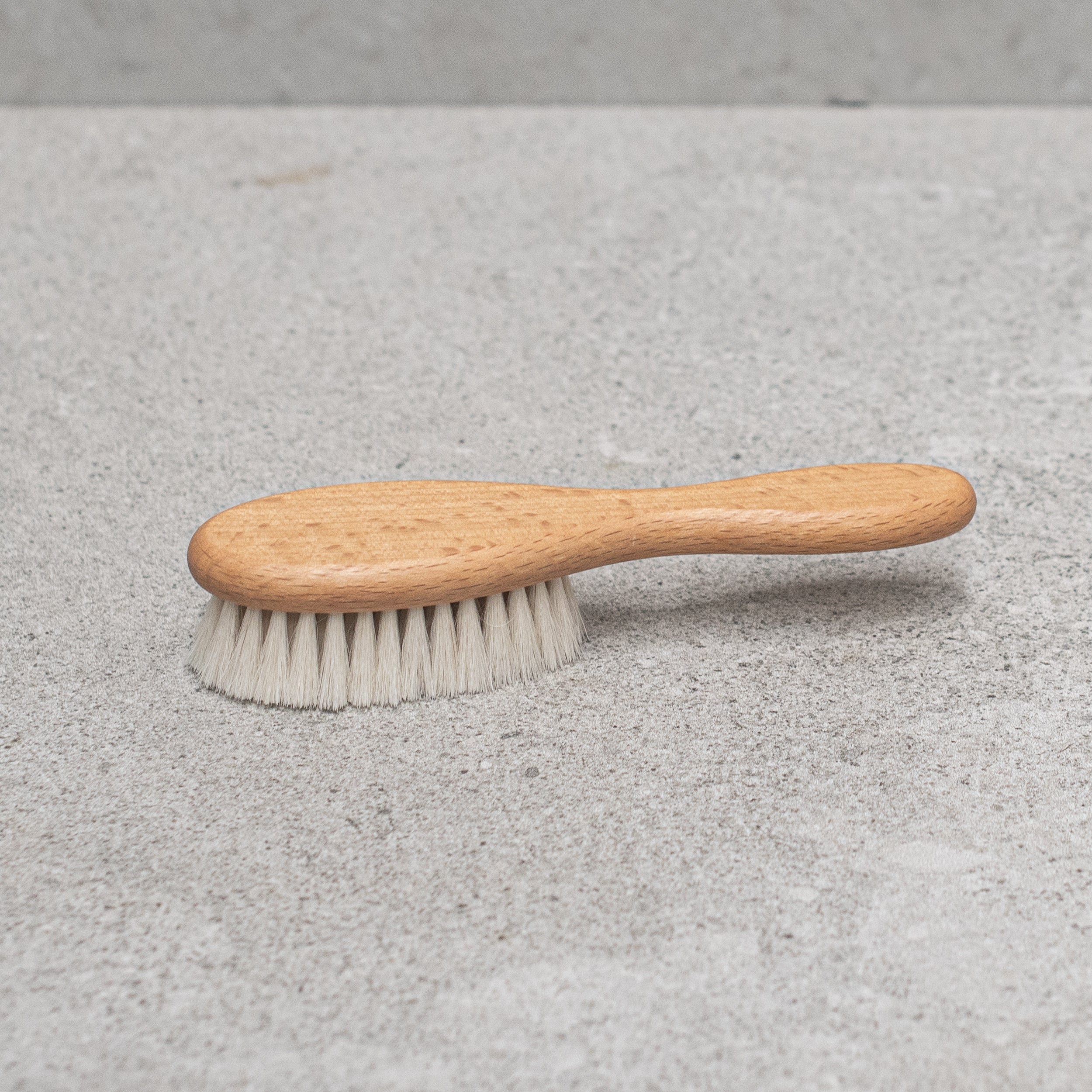 Soft goats hair baby brush with a gentle wooden handle, designed to care for delicate baby hair and sensitive scalps