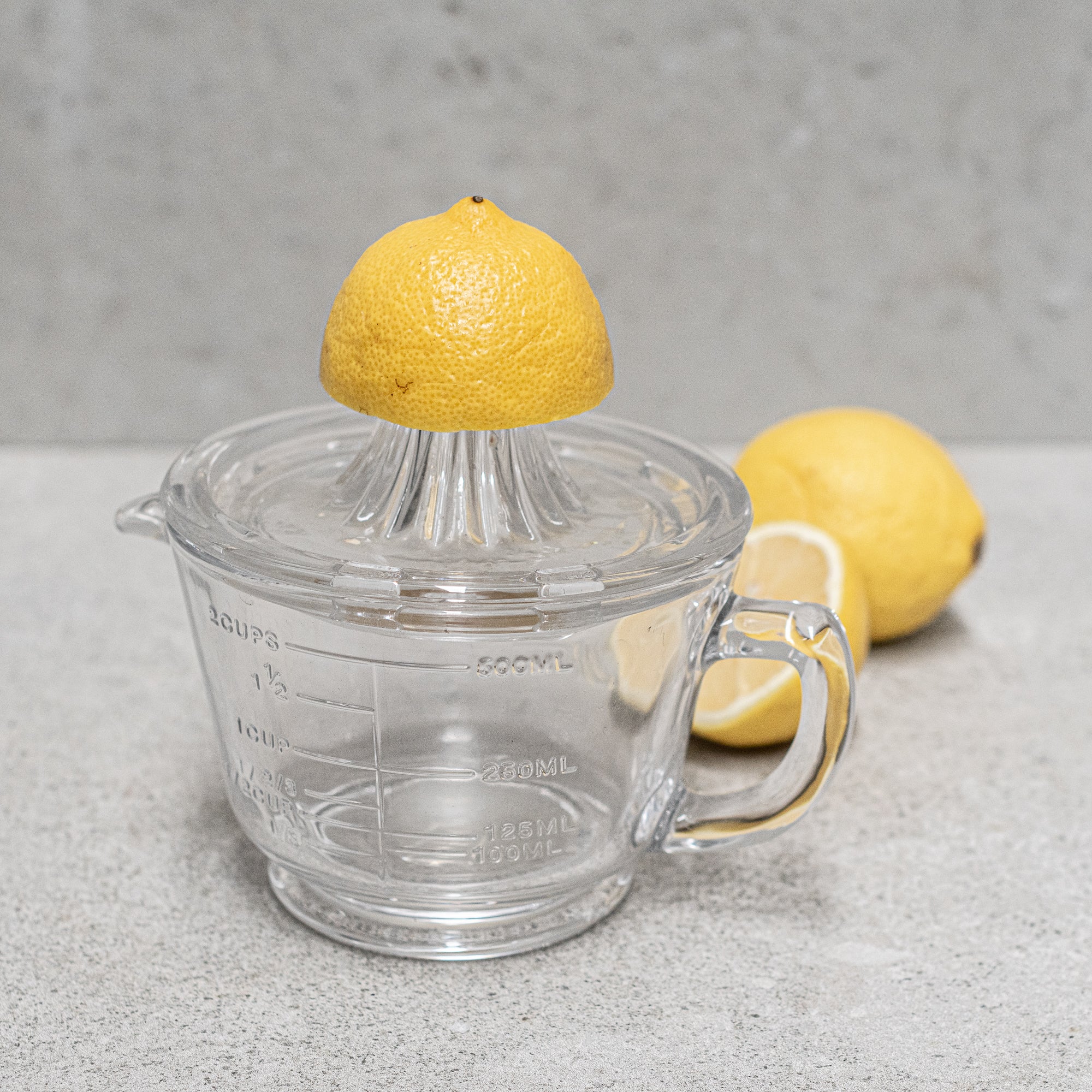 Glass citrus juicer and measuring jug, designed for effortless juicing with a built-in pour spout and measurement markings, perfect for squeezing and serving fresh juice