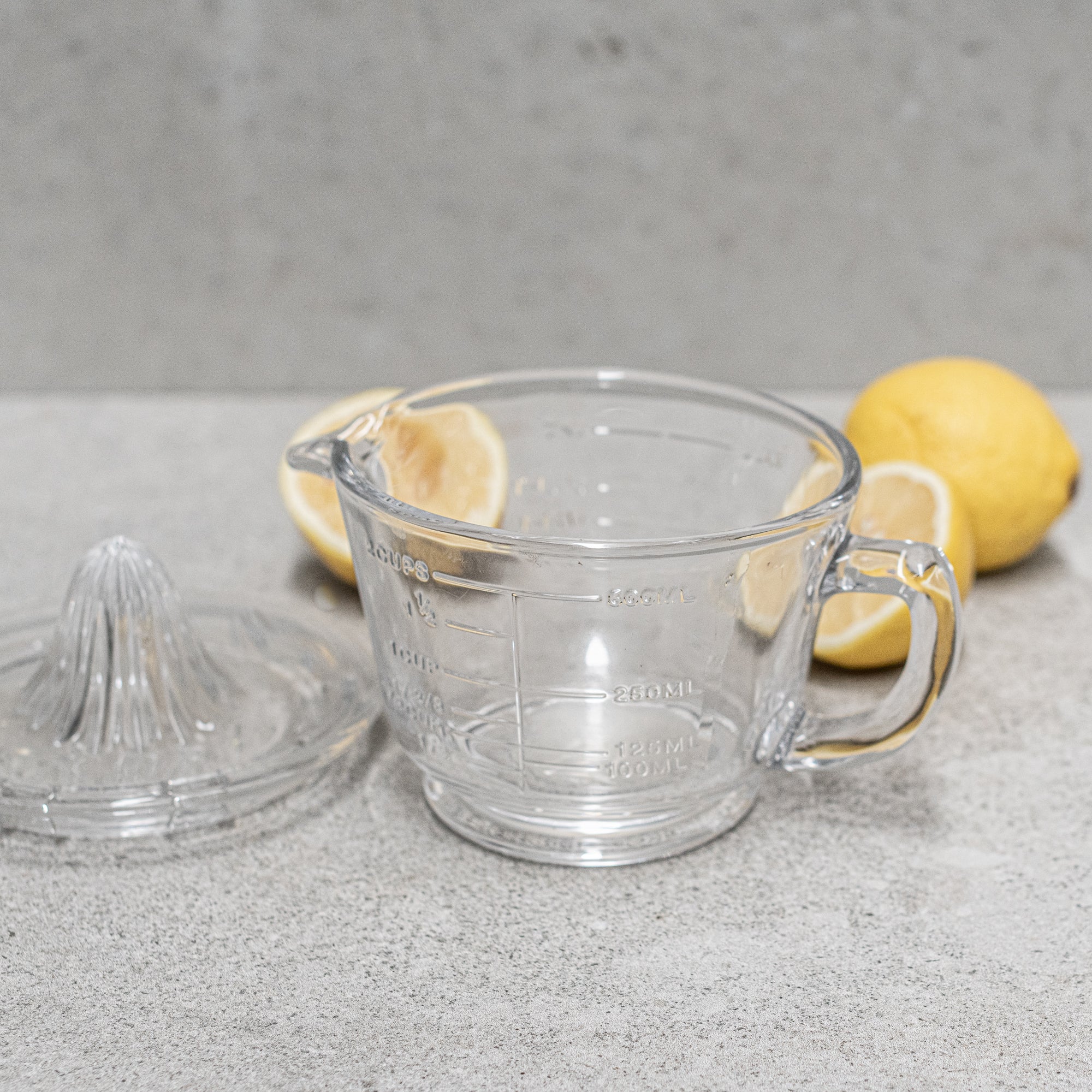Glass citrus juicer and measuring jug, designed for effortless juicing with a built-in pour spout and measurement markings, perfect for squeezing and serving fresh juice. Heaven In Earth