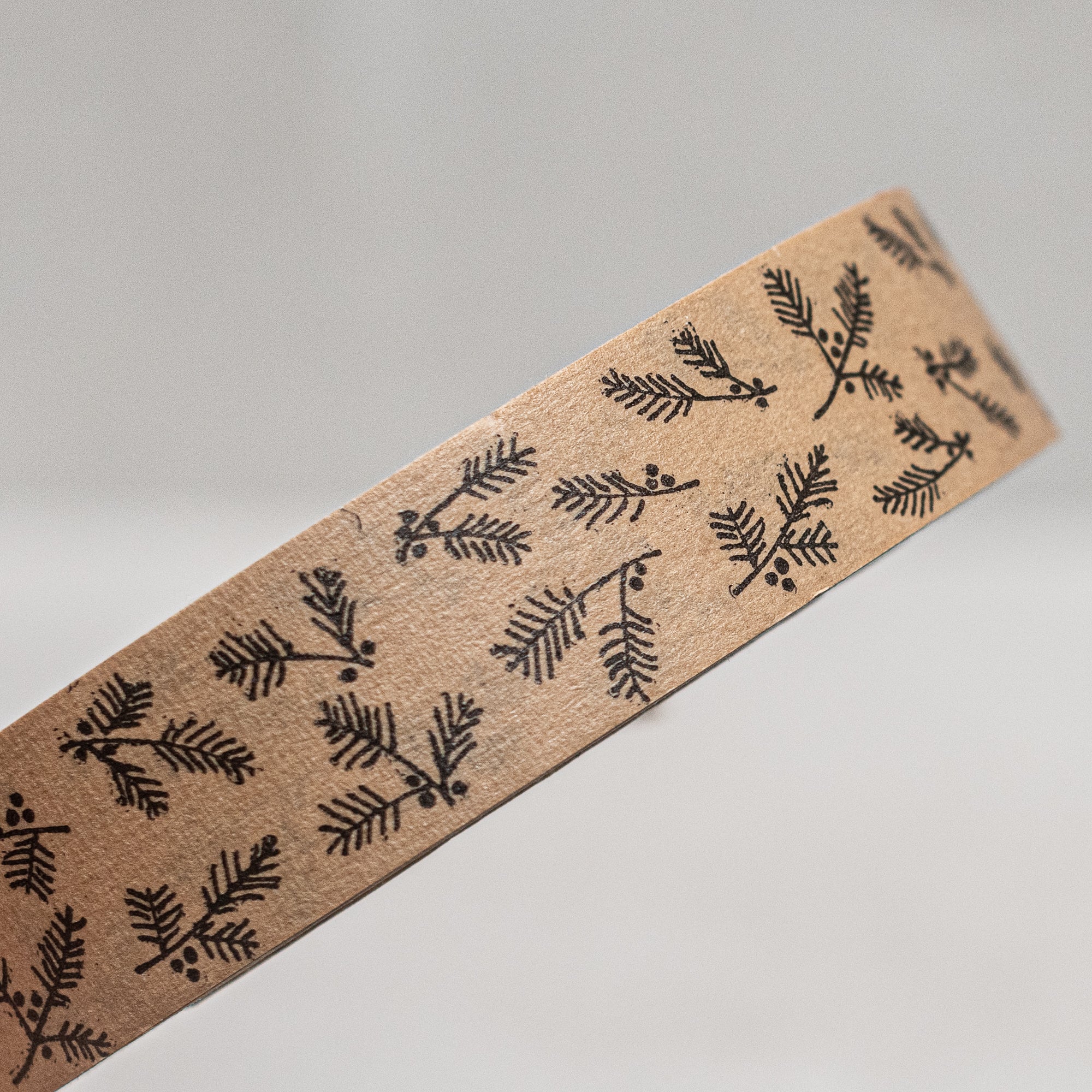 Printed brown paper tape by East of India, UK, featuring a charming designs of berries, holly and houses, perfect for wrapping gifts or adding a rustic touch to packages and crafts