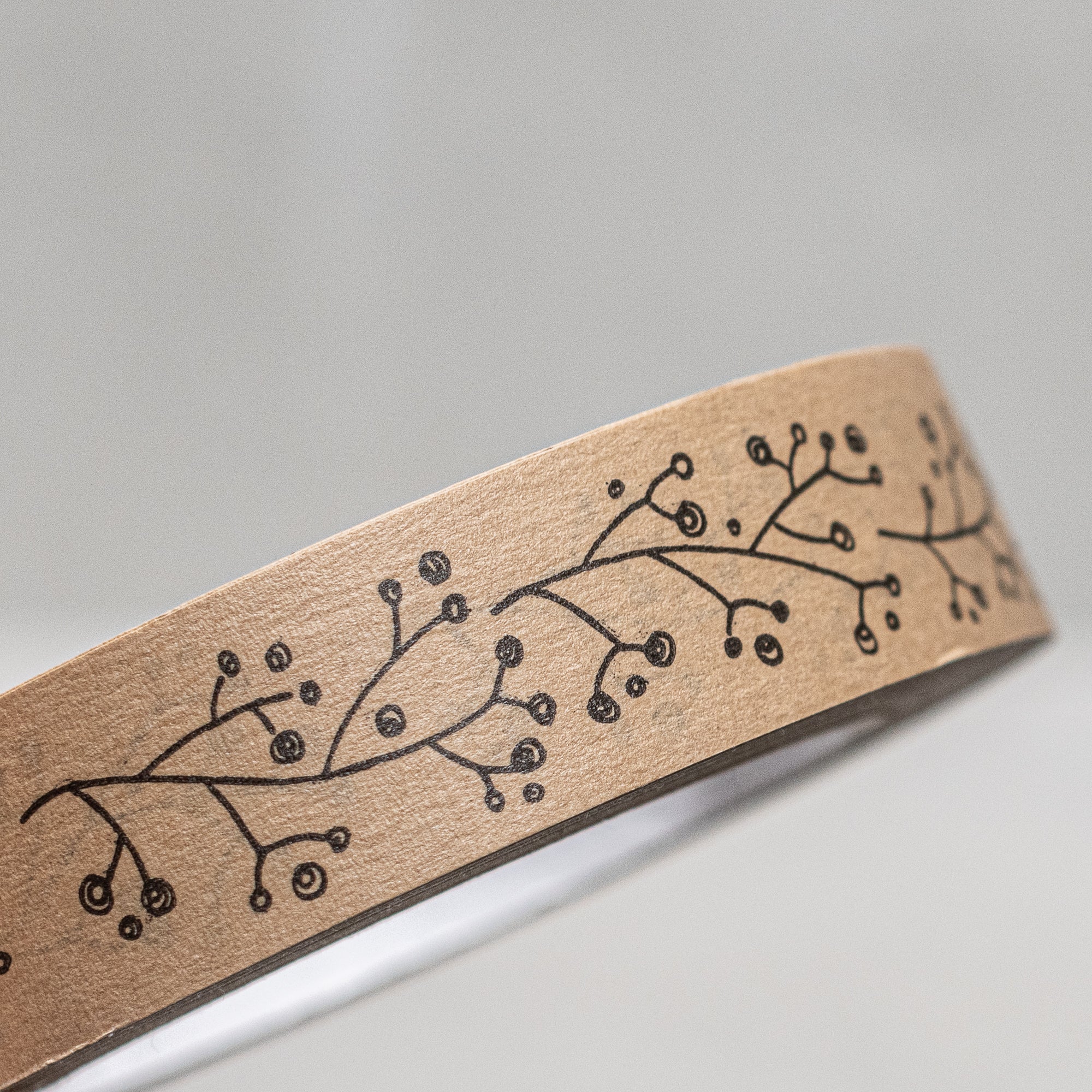 Printed brown paper tape by East of India, UK, featuring a charming designs of berries, holly and houses, perfect for wrapping gifts or adding a rustic touch to packages and crafts