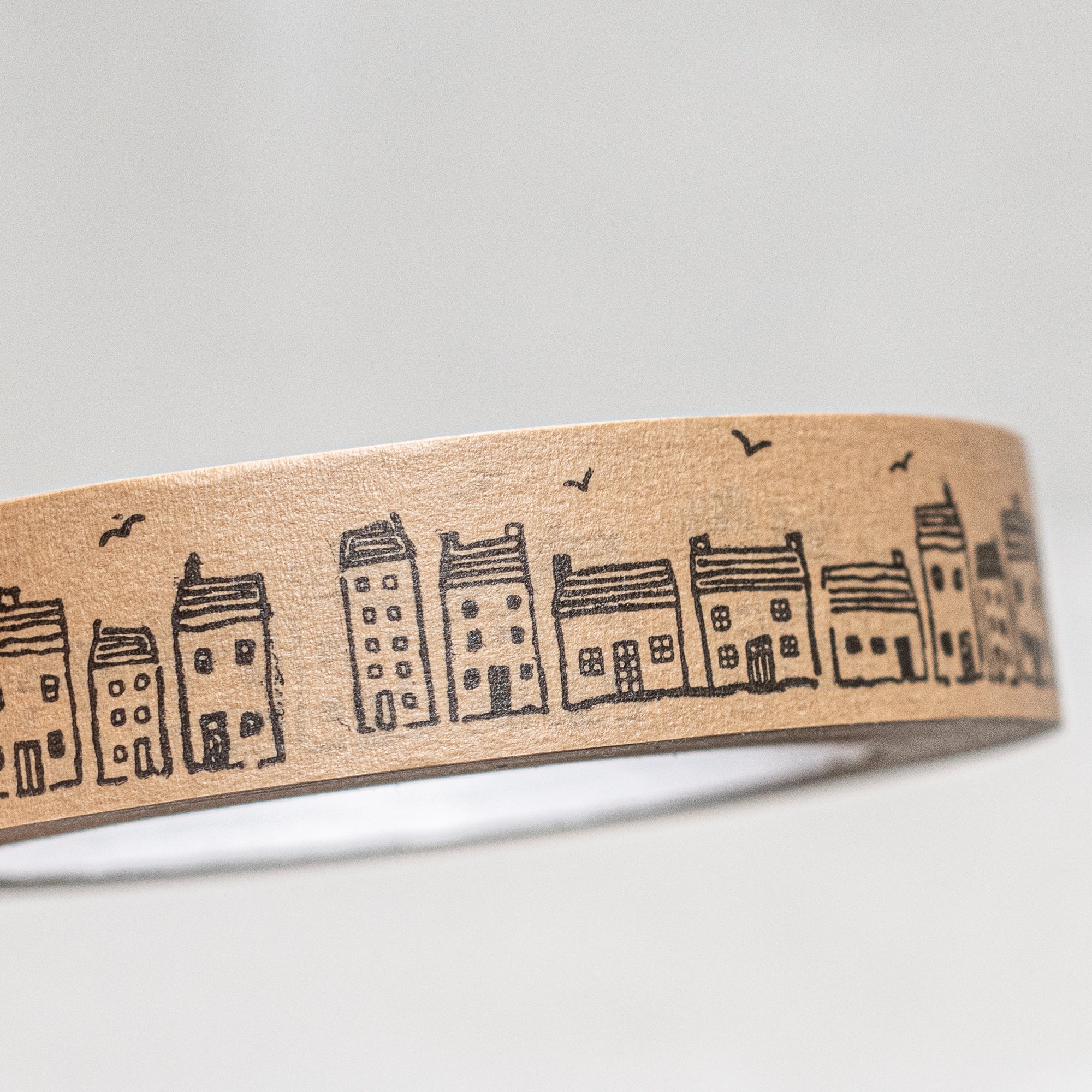 Printed brown paper tape by East of India, UK, featuring a charming designs of berries, holly and houses, perfect for wrapping gifts or adding a rustic touch to packages and crafts