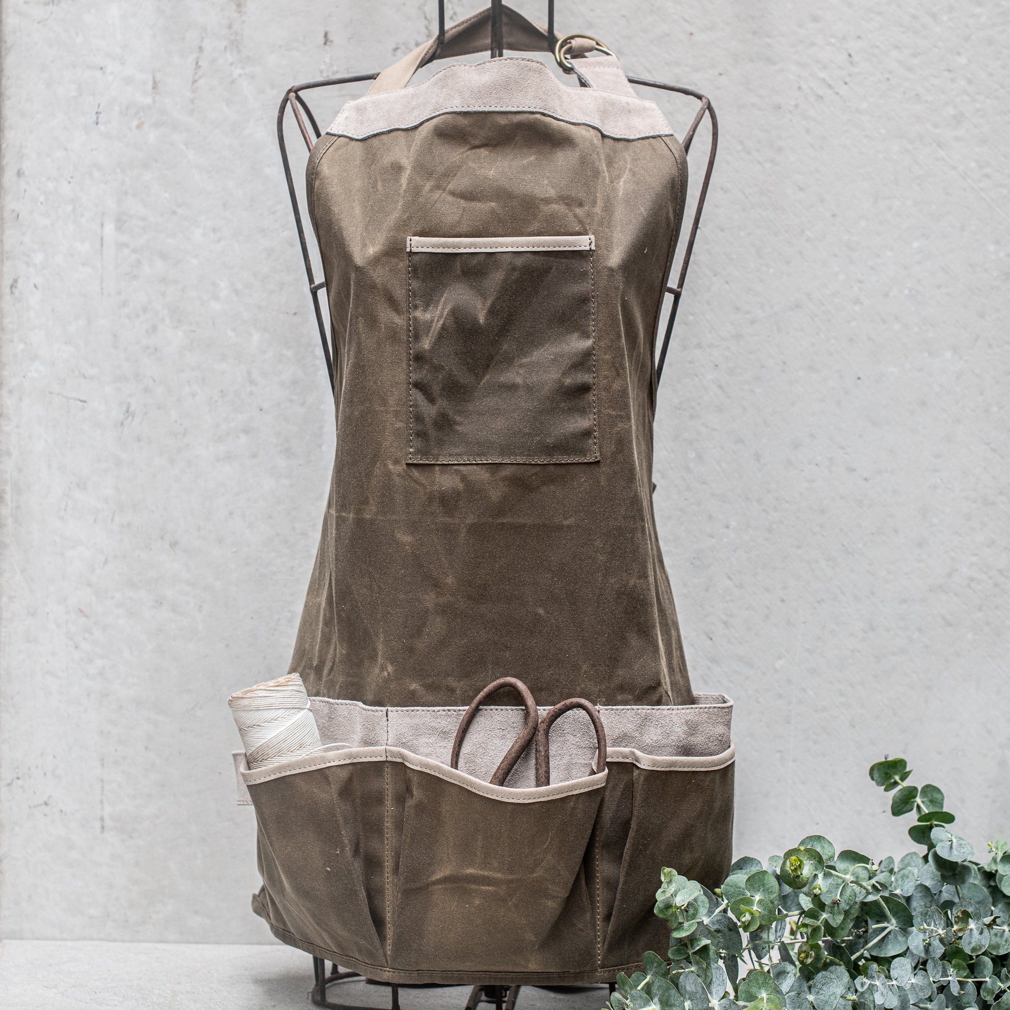Waxed Canvas and Suede Apron by Heaven in Earth, designed for durability and style. Featuring a rugged waxed canvas body with soft suede accents, this apron is perfect for cooking, gardening, or crafting. Its adjustable straps and functional pockets make it as practical as it is fashionable, offering protection while adding a rustic, earthy touch to any task
