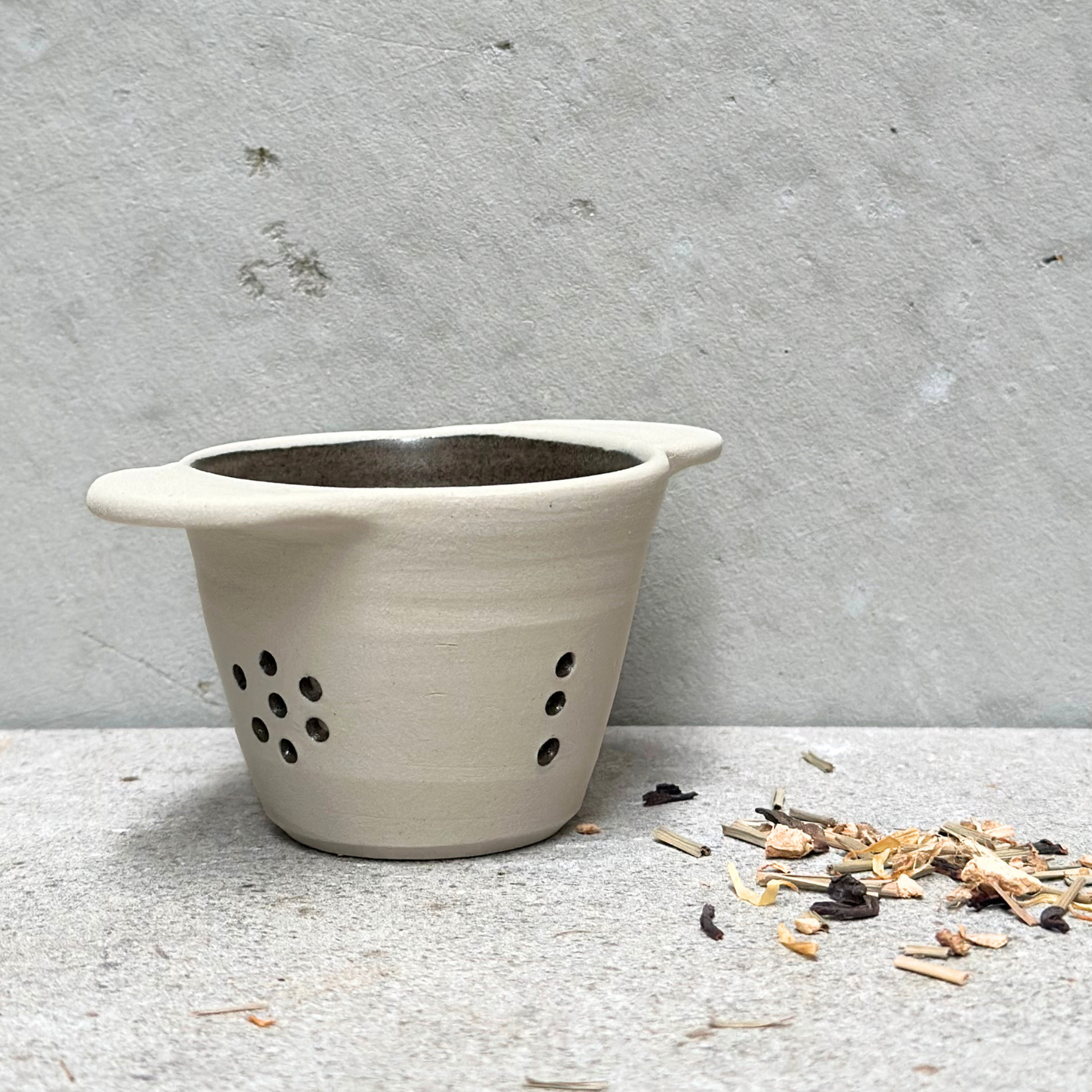Handmade ceramic tea strainer with side handles for brewing loose leaf tea, made in Sydney, Australia.