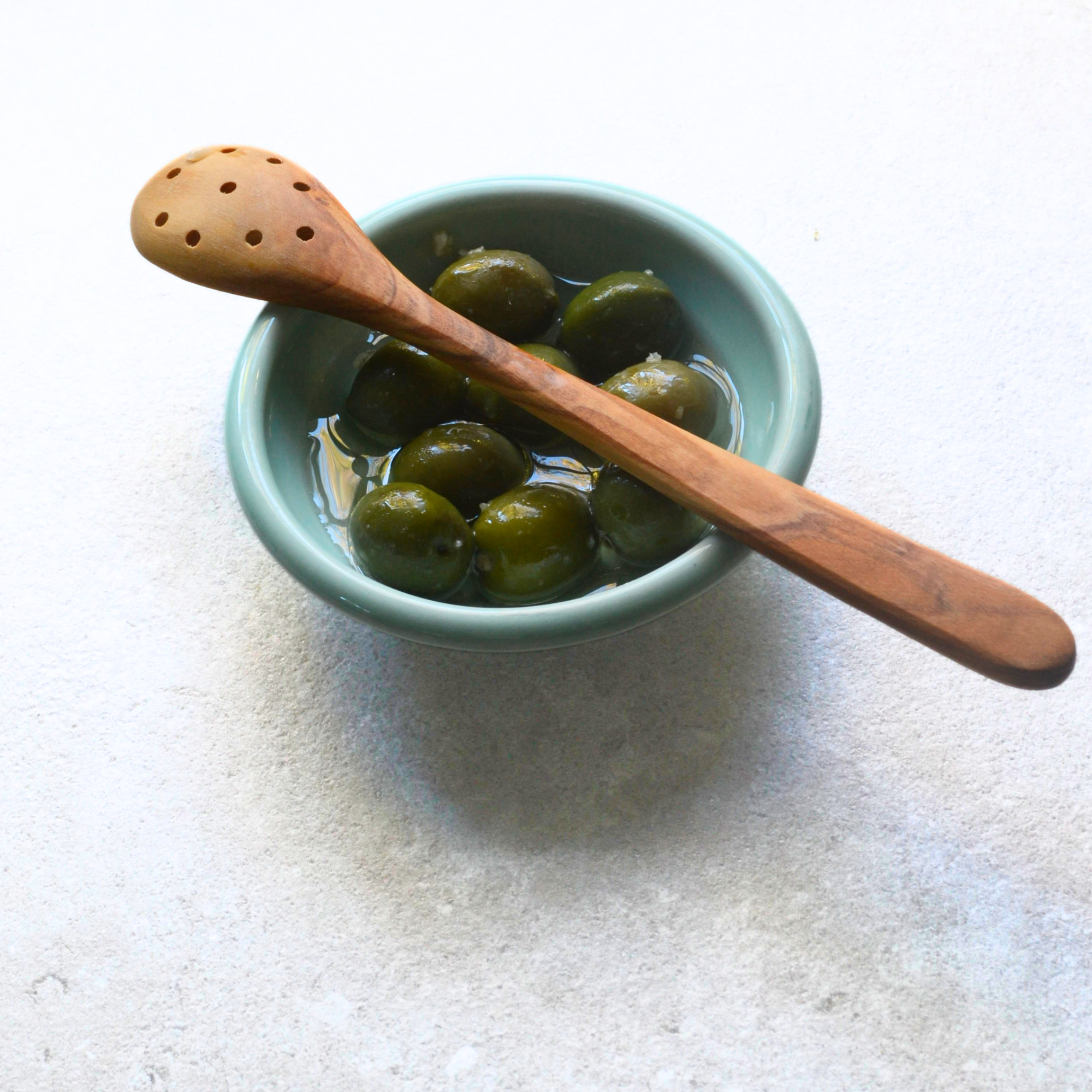 small olive wood holed spoon kitchen utensil