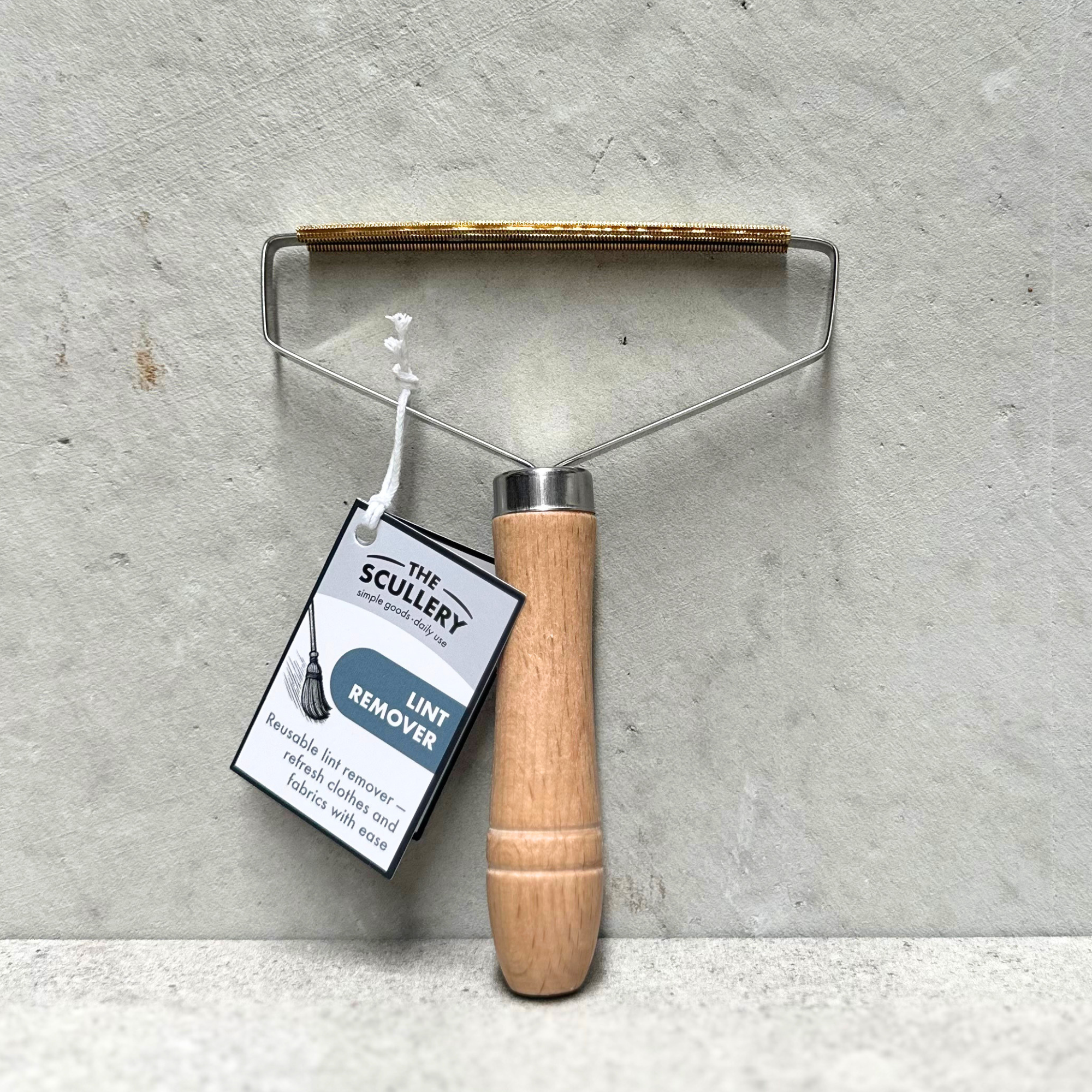 Wooden handle metal lint remover