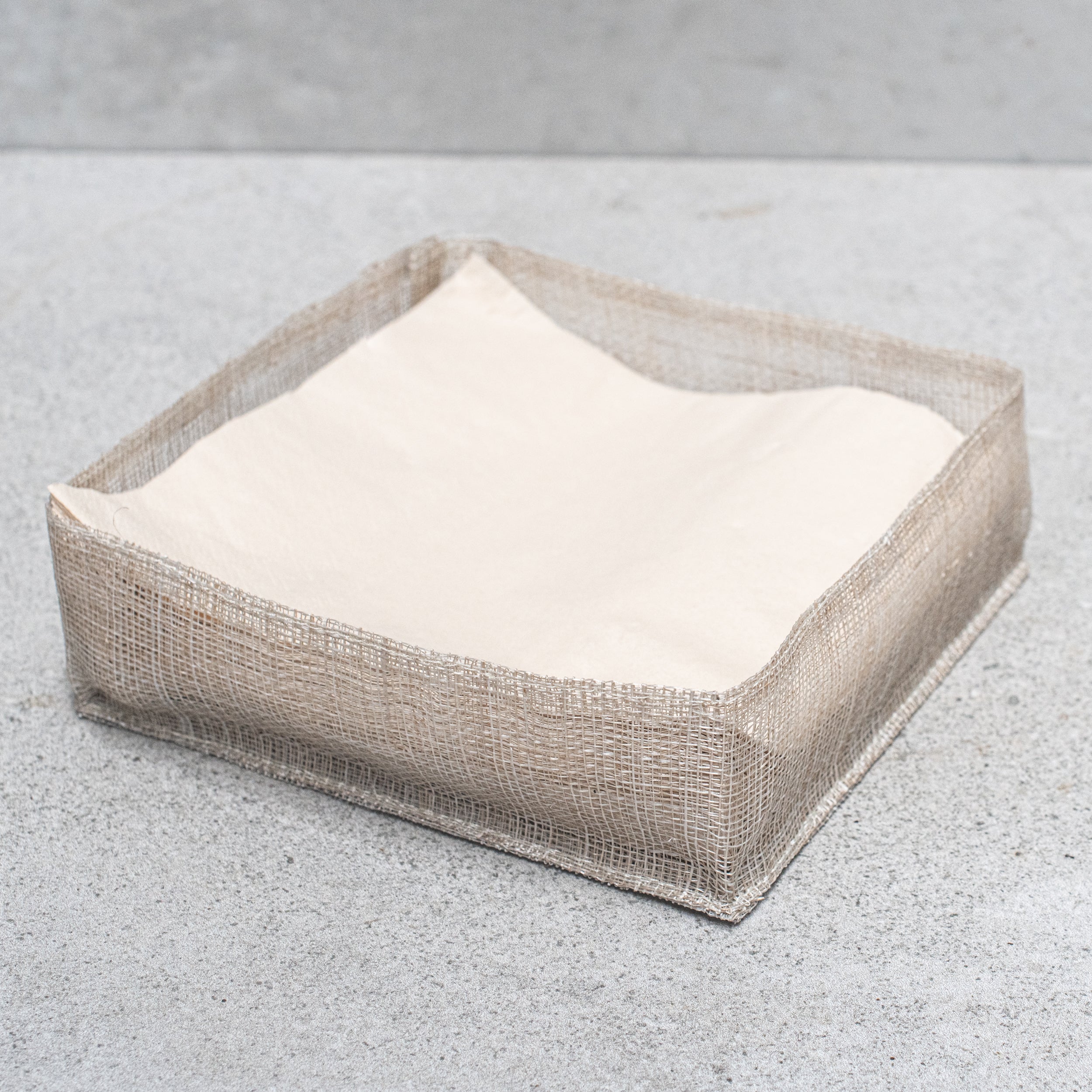 Abaca fibre napkin holder, handcrafted with a natural woven design, offering a rustic and eco-friendly touch to your dining table.