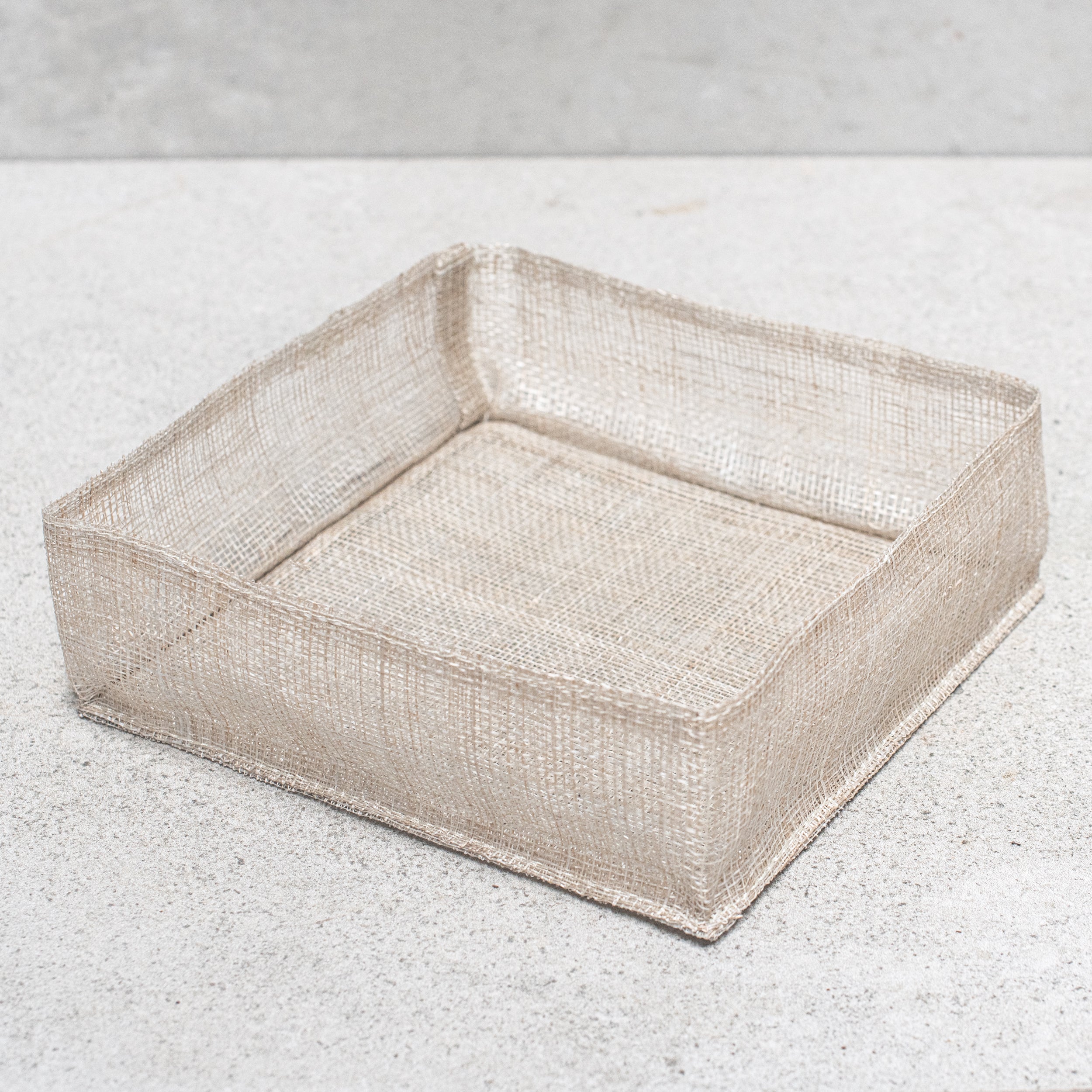 Abaca fibre napkin holder, handcrafted with a natural woven design, offering a rustic and eco-friendly touch to your dining table.