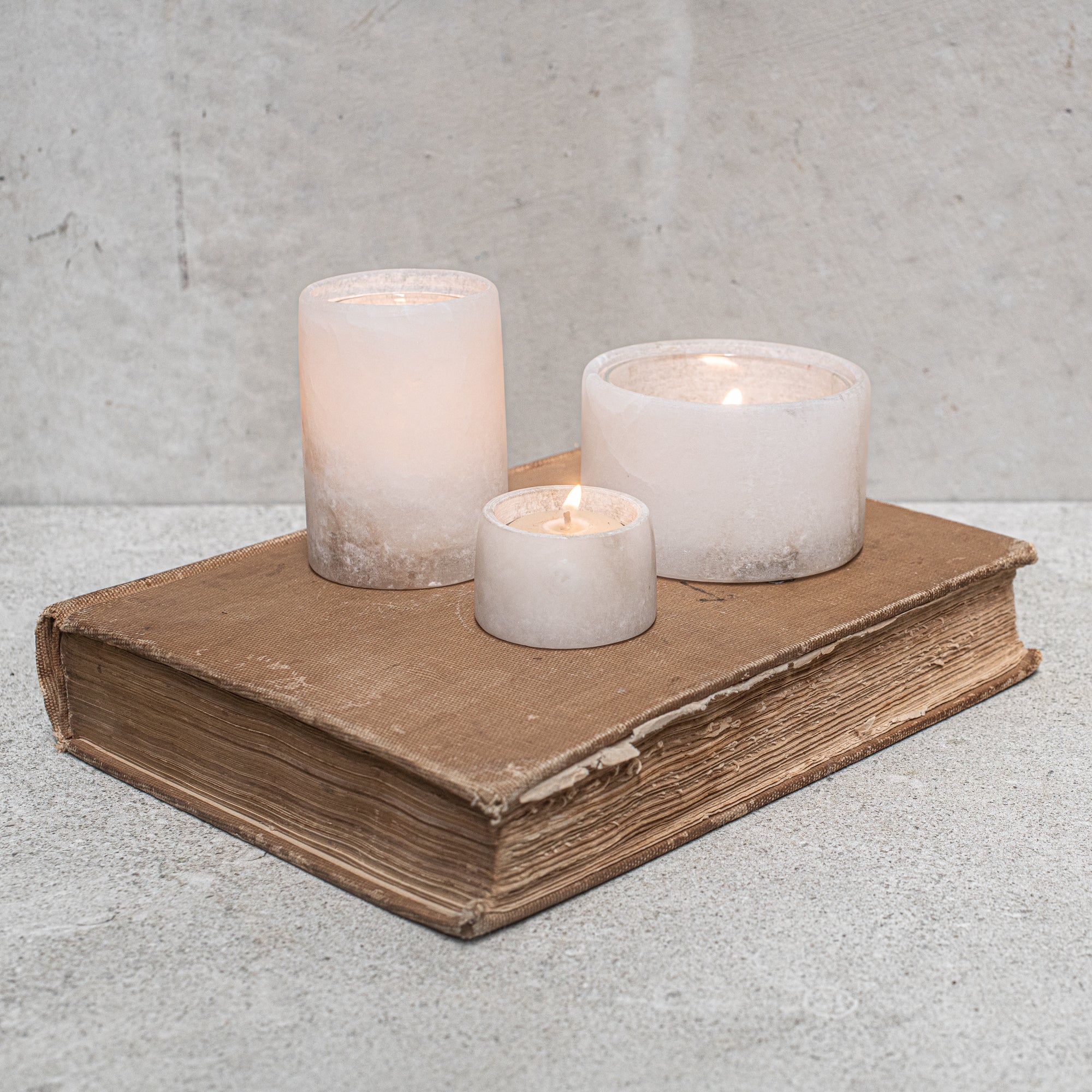 Set of alabaster votives, featuring a smooth, translucent design that gently diffuses light for a warm, ambient glow