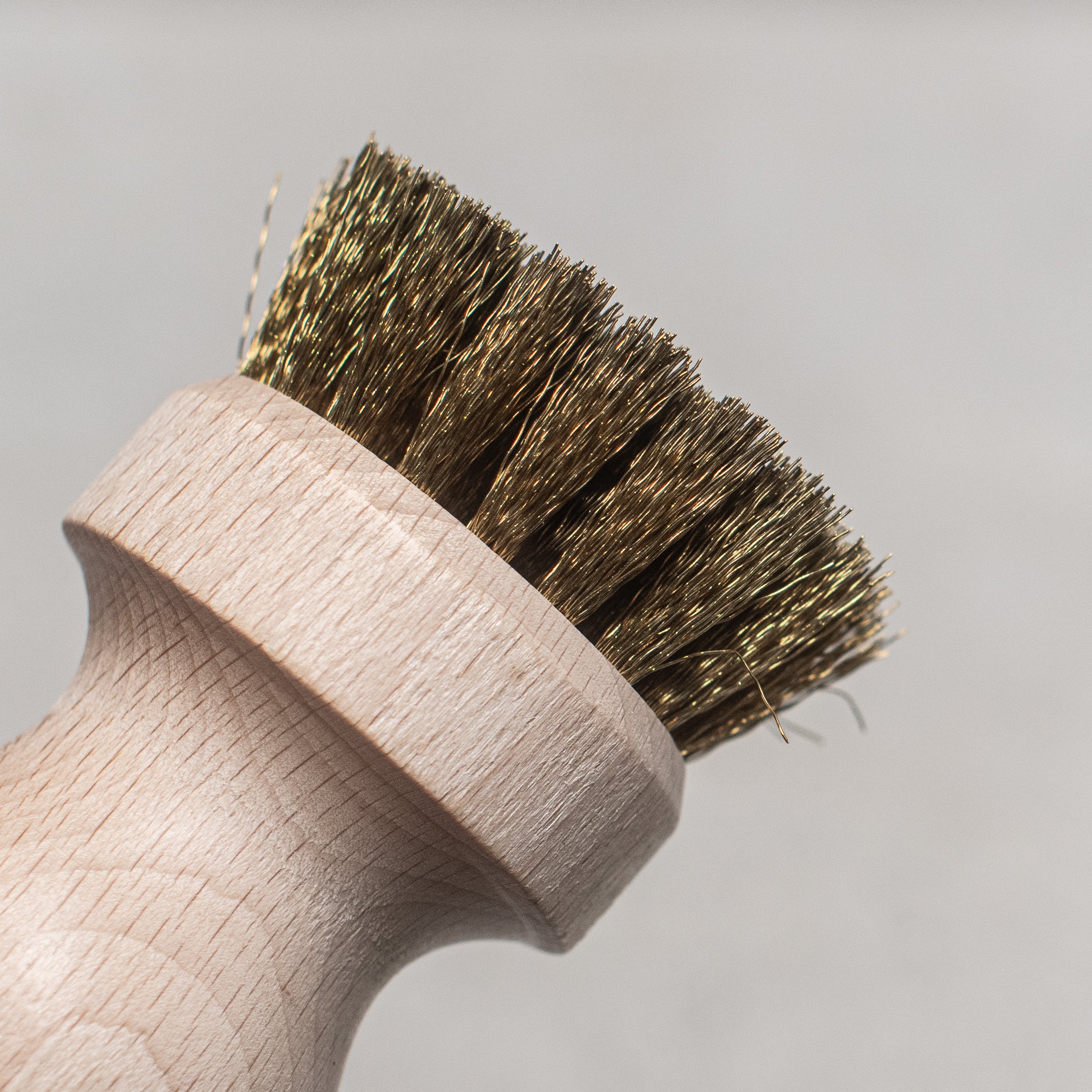 BBQ brush with brass wire bristles and a wooden handle, designed for easy and efficient cleaning of grill grates