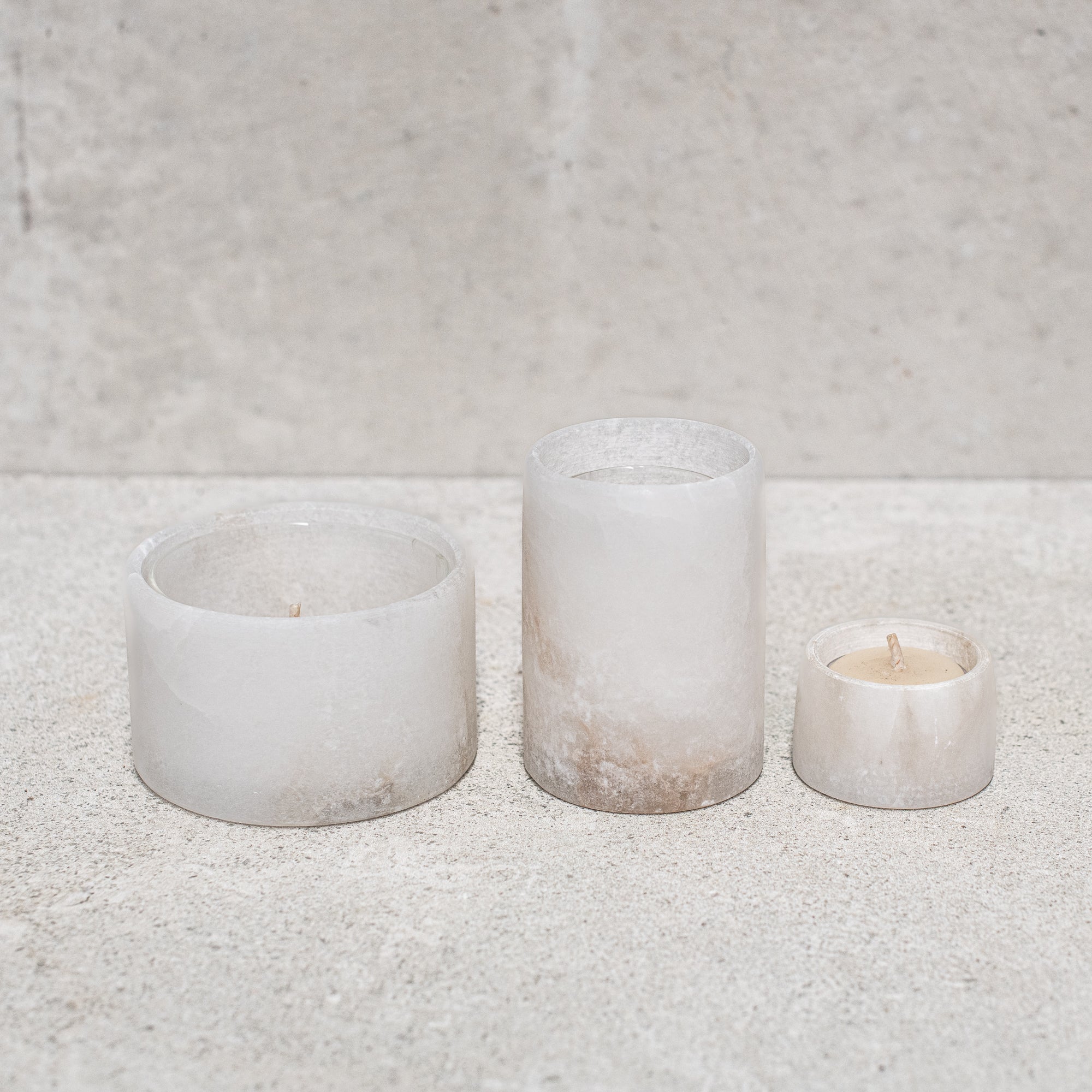 Set of alabaster votives, featuring a smooth, translucent design that gently diffuses light for a warm, ambient glow