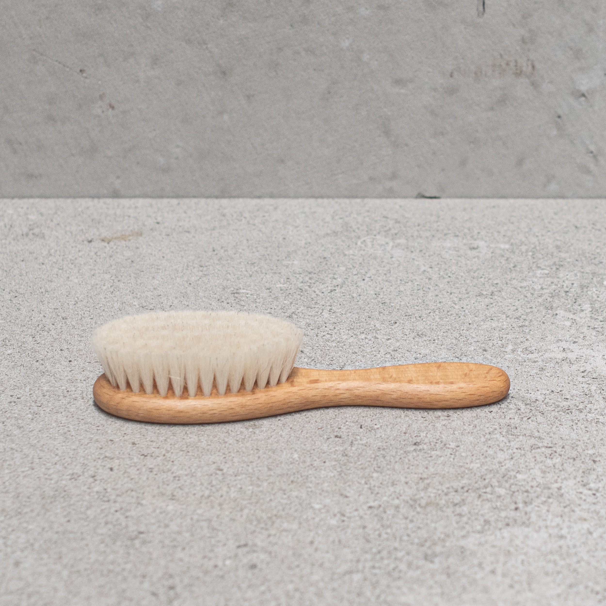 Soft goats hair baby brush with a gentle wooden handle, designed to care for delicate baby hair and sensitive scalps