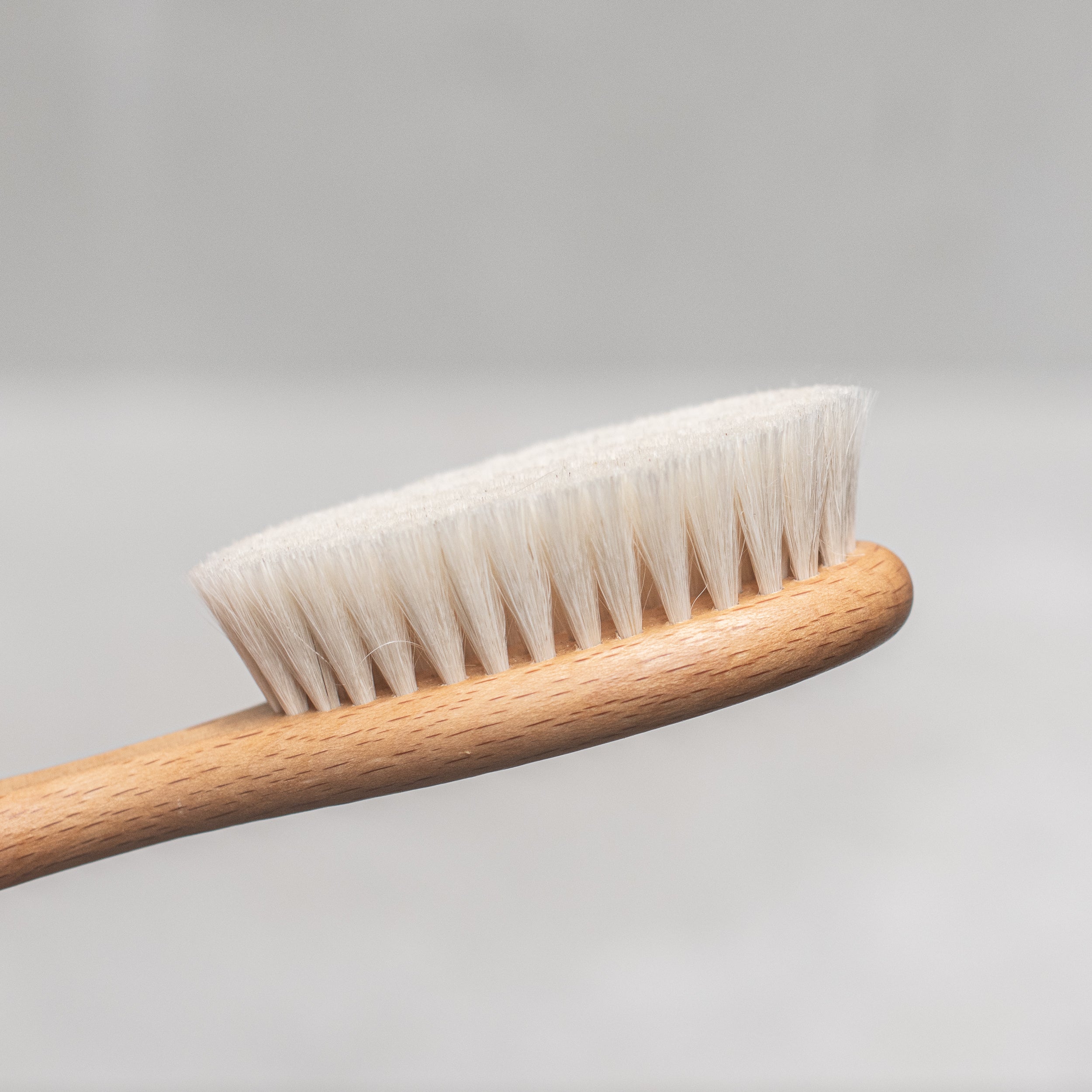 Soft goats hair baby brush with a gentle wooden handle, designed to care for delicate baby hair and sensitive scalps