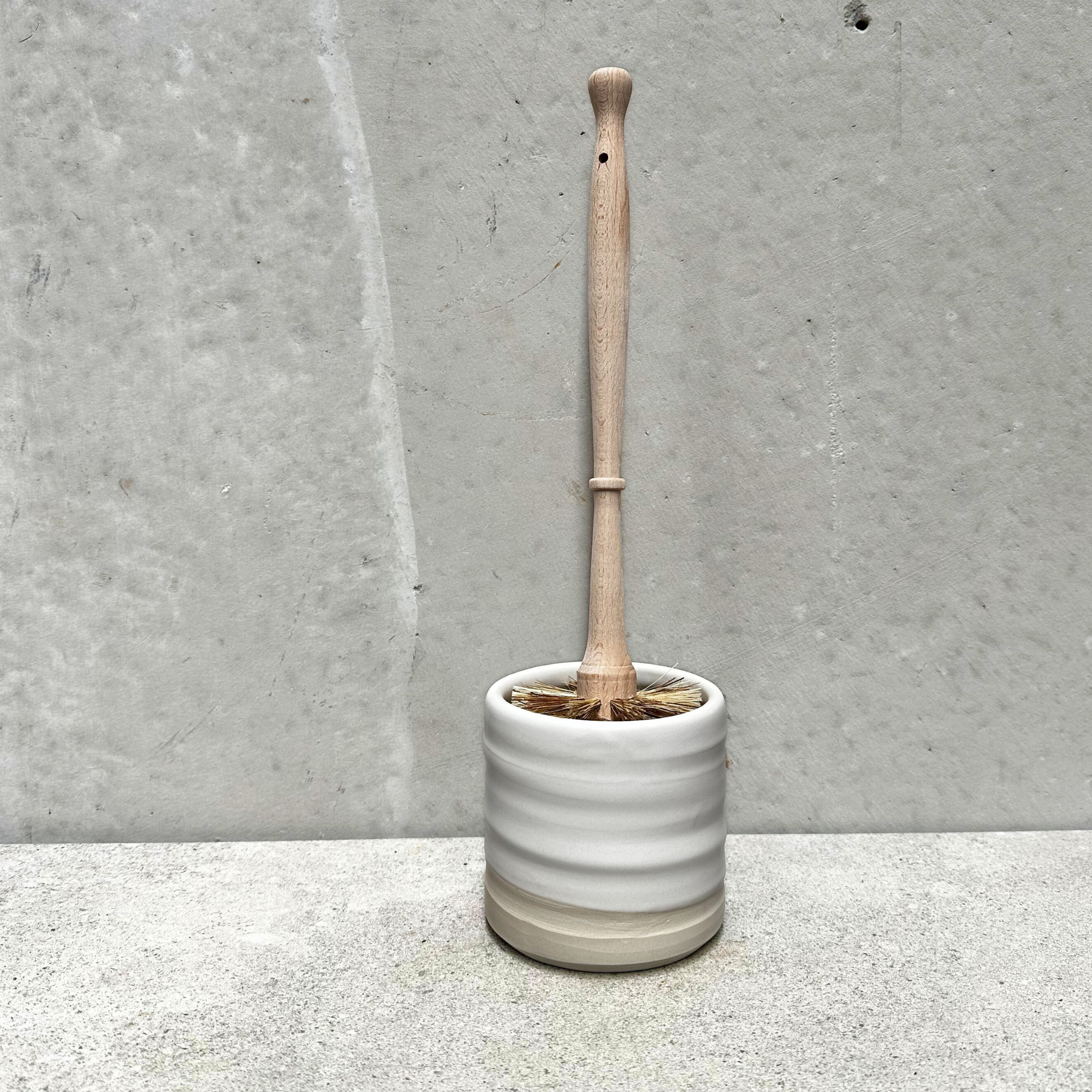 Neutral handmade ceramic holder with an eco friendly wooden toilet brush inside, designed for modern bathroom decor