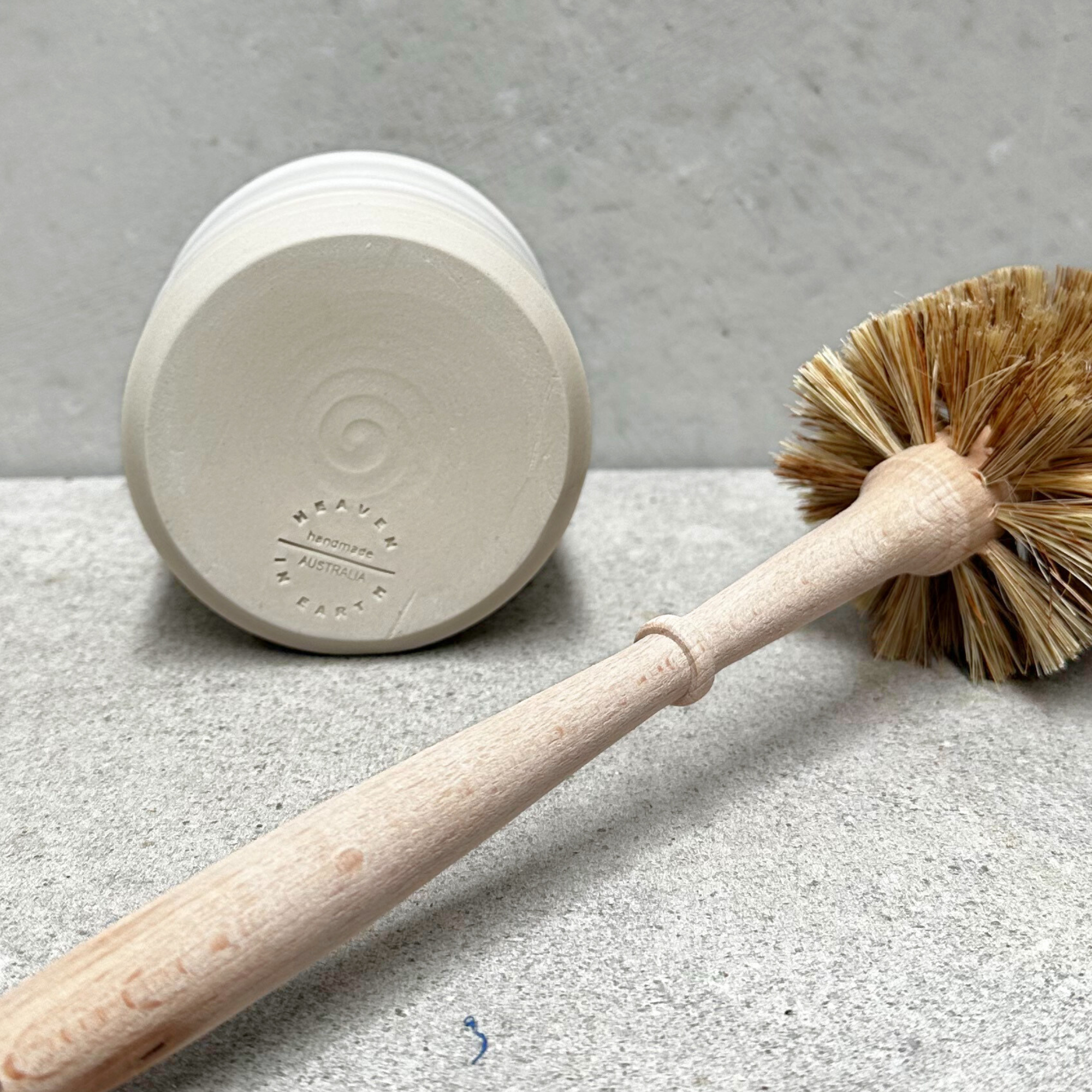 Neutral handmade ceramic holder with an eco friendly wooden toilet brush inside, designed for modern bathroom decor