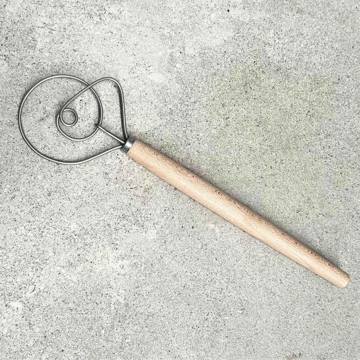 Danish dough mixer with stainless steel looped mixing head and natural beechwood handle, made in Germany.