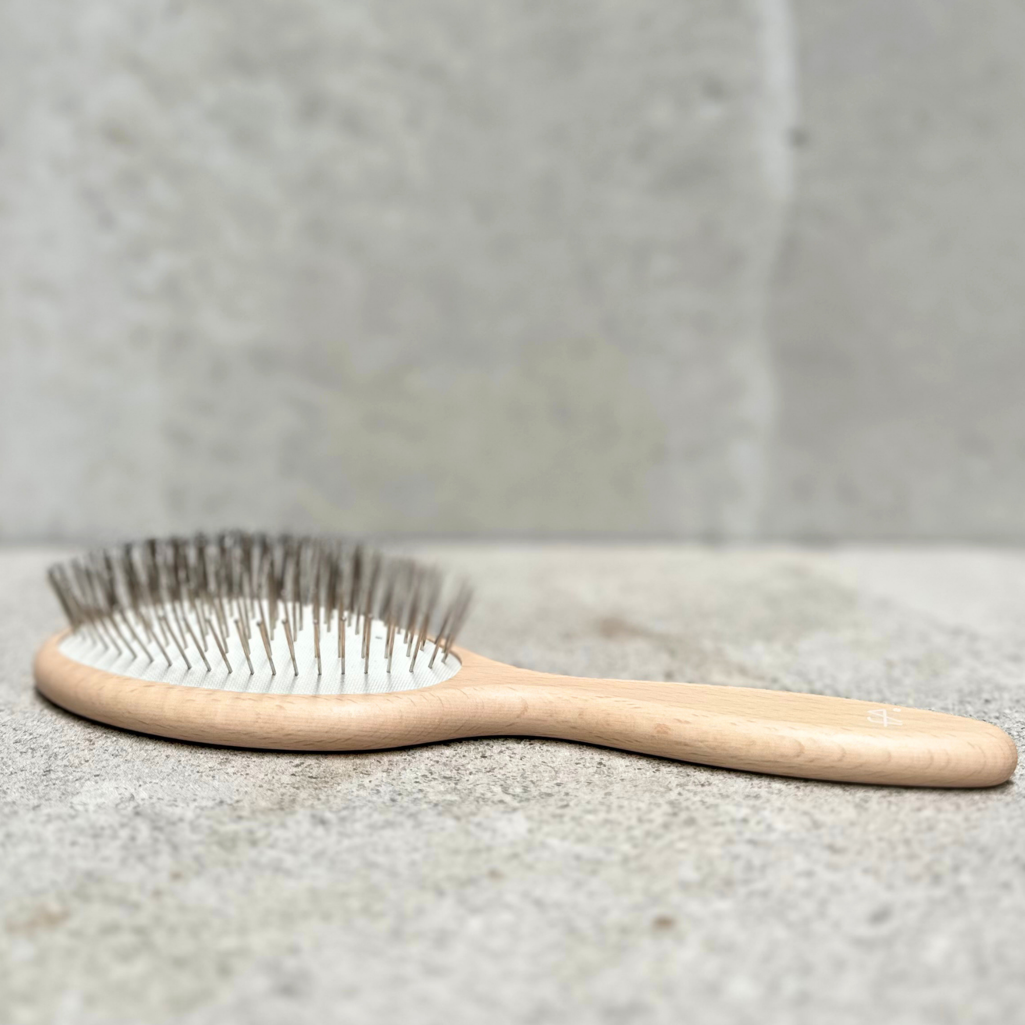 Beach and pool hair brush with flexible steel pins and varnished beechwood handle by Faller Germany.
