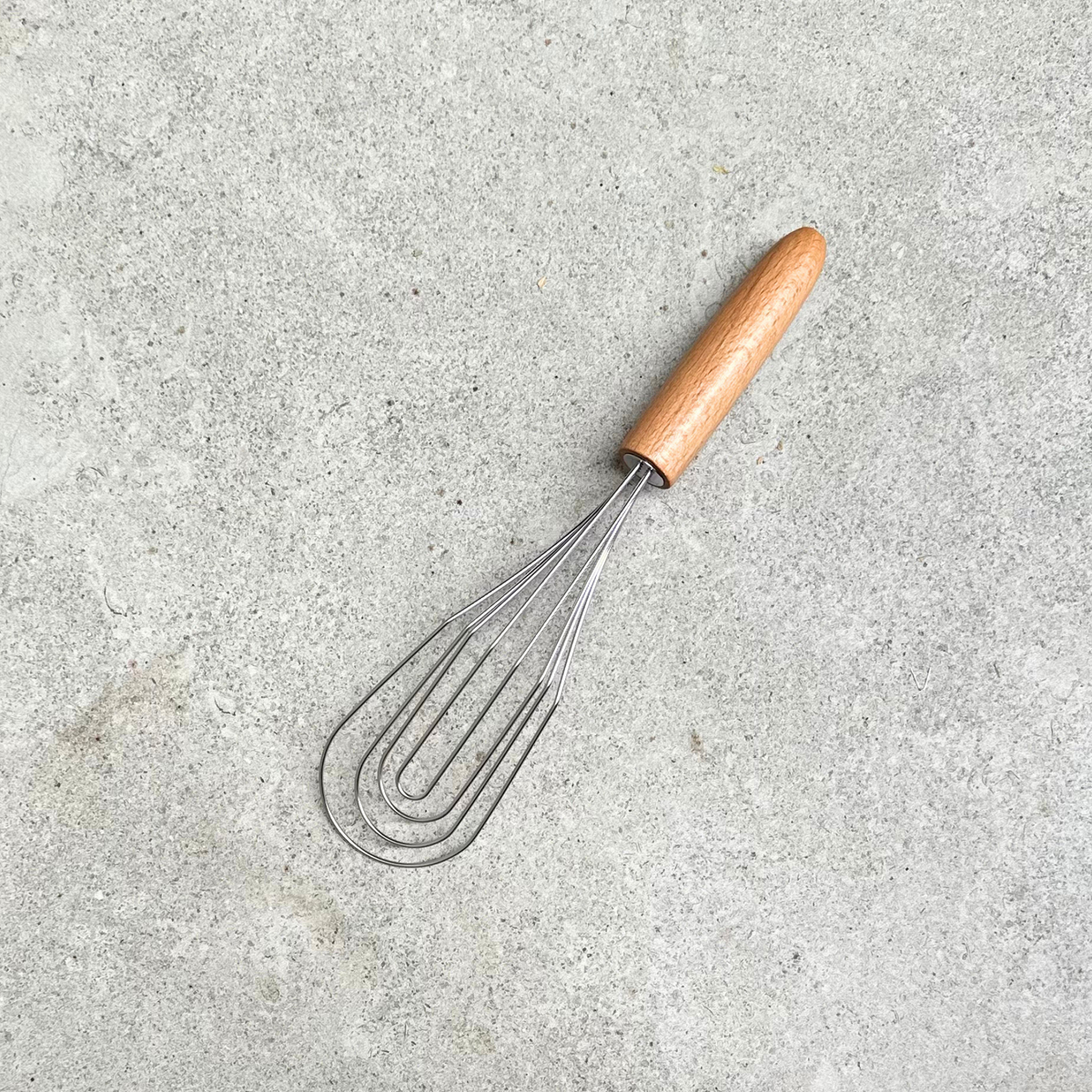 Flat-head stainless steel whisk with FSC® beechwood handle, designed for smooth mixing and sauce making, made in Germany.