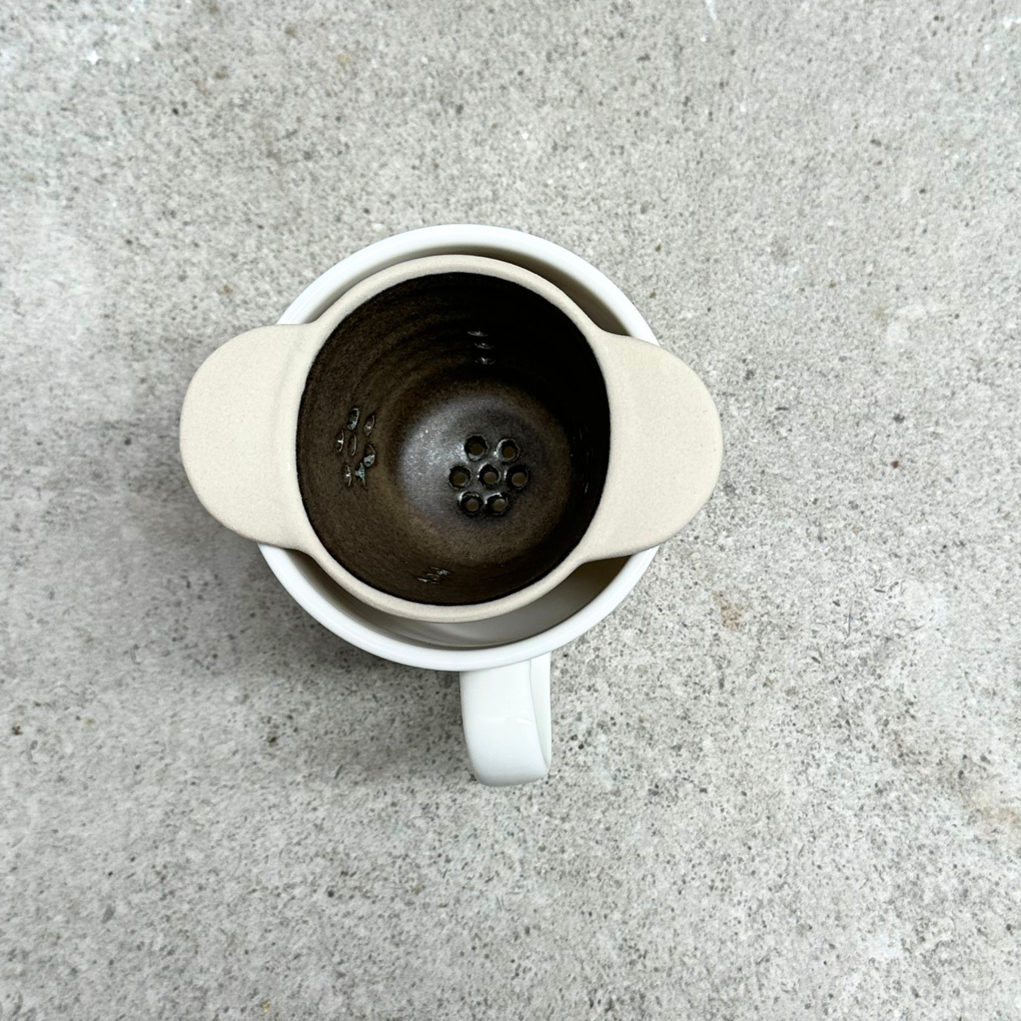 Handmade ceramic tea strainer with side handles for brewing loose leaf tea, made in Sydney, Australia.