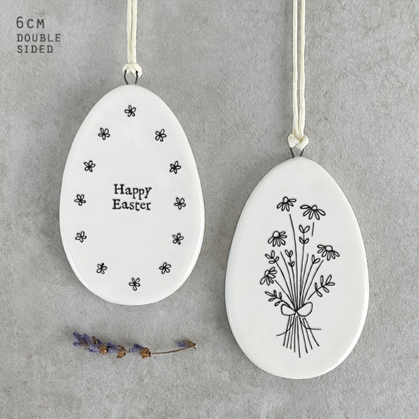 eaven in Earth (HIE) porcelain hanging Easter egg, featuring a charming 'Happy Easter' design by East of India. This delicate, handcrafted ornament adds a festive, whimsical touch to your spring décor or Easter celebrations.