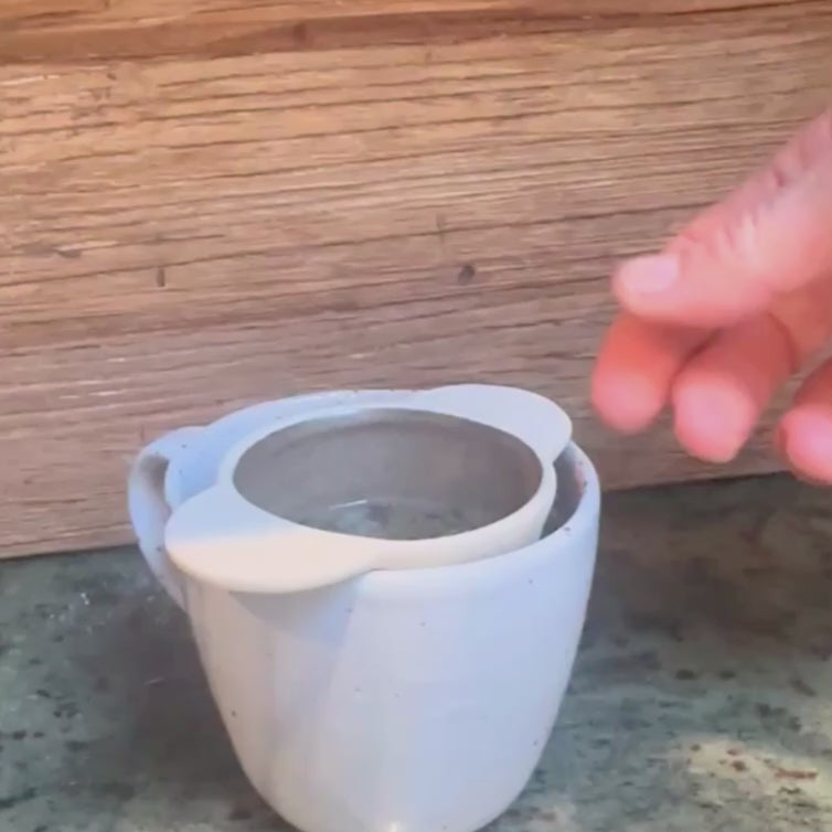 Handmade ceramic tea strainer with side handles for brewing loose leaf tea, made in Sydney, Australia.